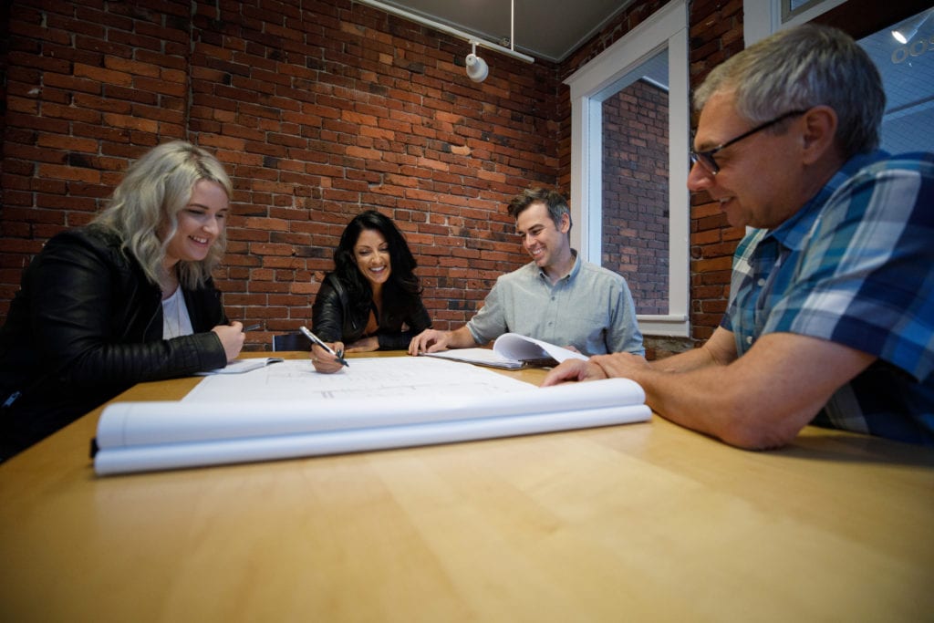 Photo: 3 team members at table with plans