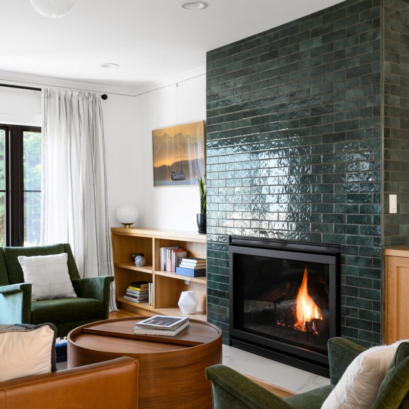 Image shows a living room with a gas fireplace with a visible flame